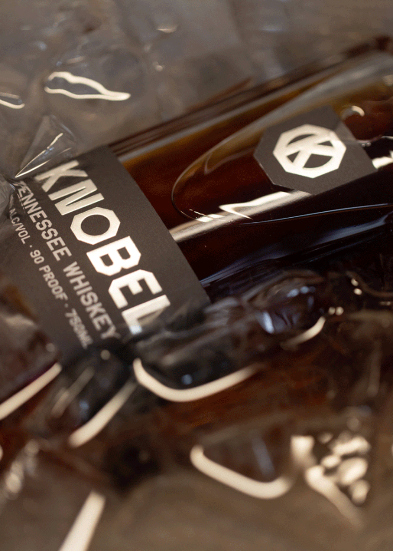 A close up shot of Knobel Tennessee Whiskey Bottle in a bucket of ice